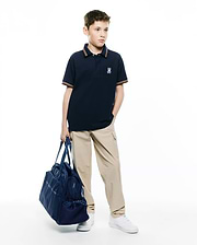 Kids Jaydon Pique Polo in navy blue, featuring a classic fit, textured pique fabric, and a small embroidered Psycho Bunny skull logo on the left chest, with orange and white striped collar and cuffs.