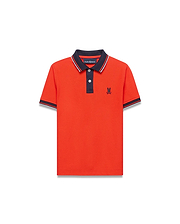 Kids Stan Pique Polo in vibrant orange-red pique knit, featuring a navy collar with white stripe, navy placket, and striped cuffs. Classic fit with small embroidered navy Psycho Bunny skull logo on left chest. (3)