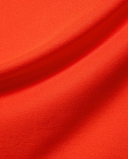 Kids Stan Pique Polo, a premium Psycho Bunny garment in a bold, vibrant orange hue. Close-up reveals the classic textured pique knit fabric with elegant, soft folds, emphasizing quality. (4)