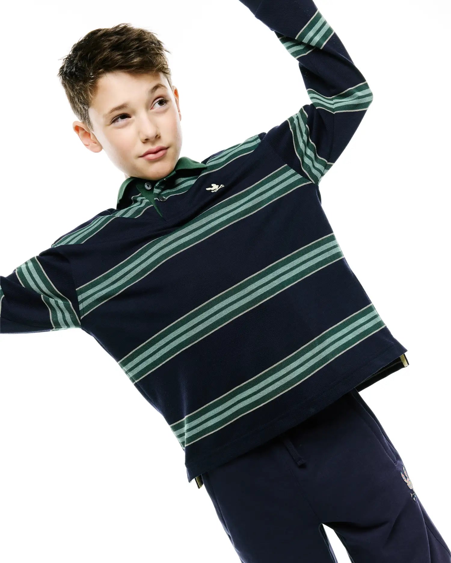 Kids Drew Striped L/S Pique Polo in classic fit navy blue pique, featuring long sleeves, a green collar, two-button placket, horizontal green and white stripes, and a small embroidered Psycho Bunny skull logo on the left chest.