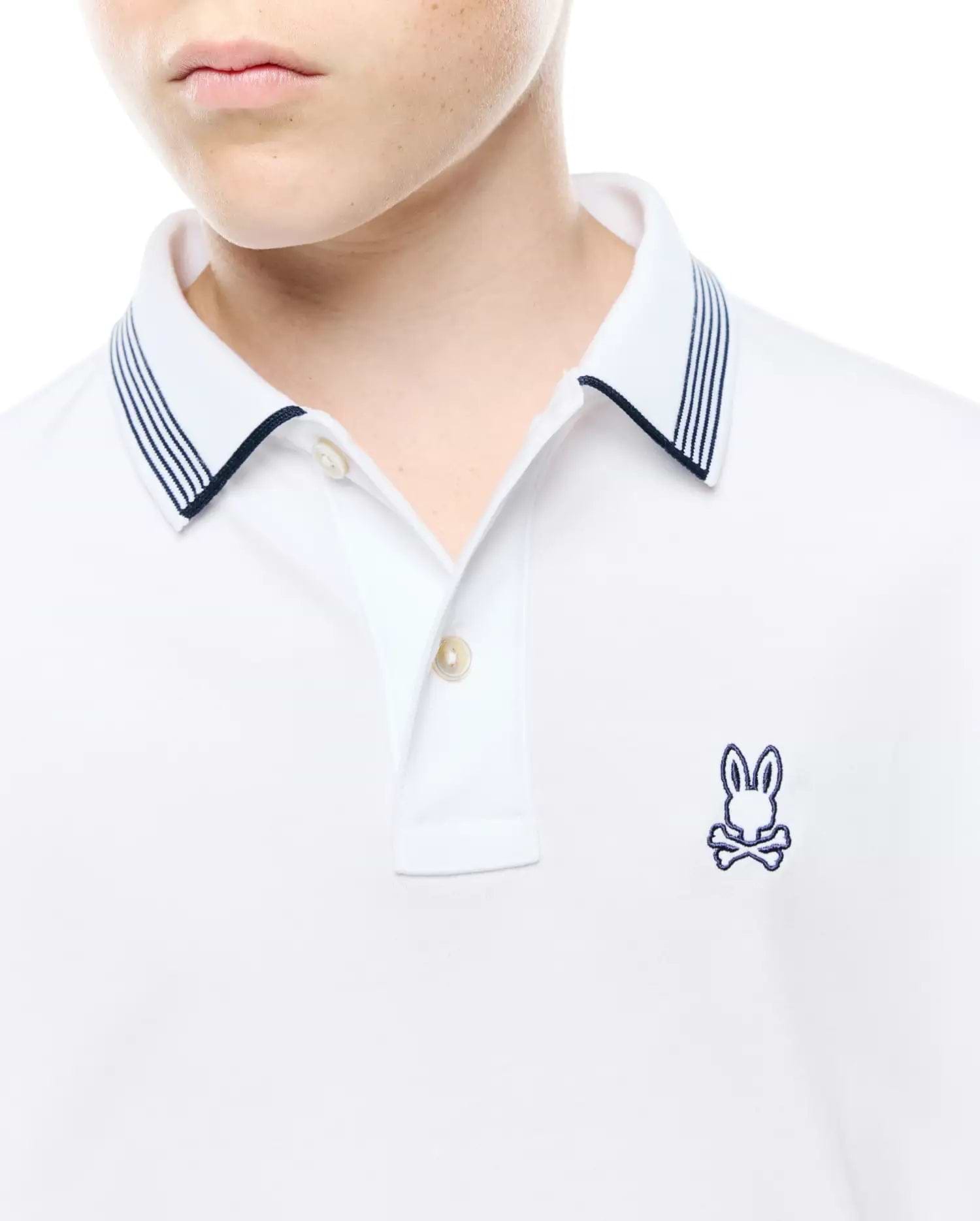 Kids Timmy Pique Polo, a classic white pique polo featuring a two-button placket, navy blue striped collar, and a small embroidered Psycho Bunny skull logo on the left chest.