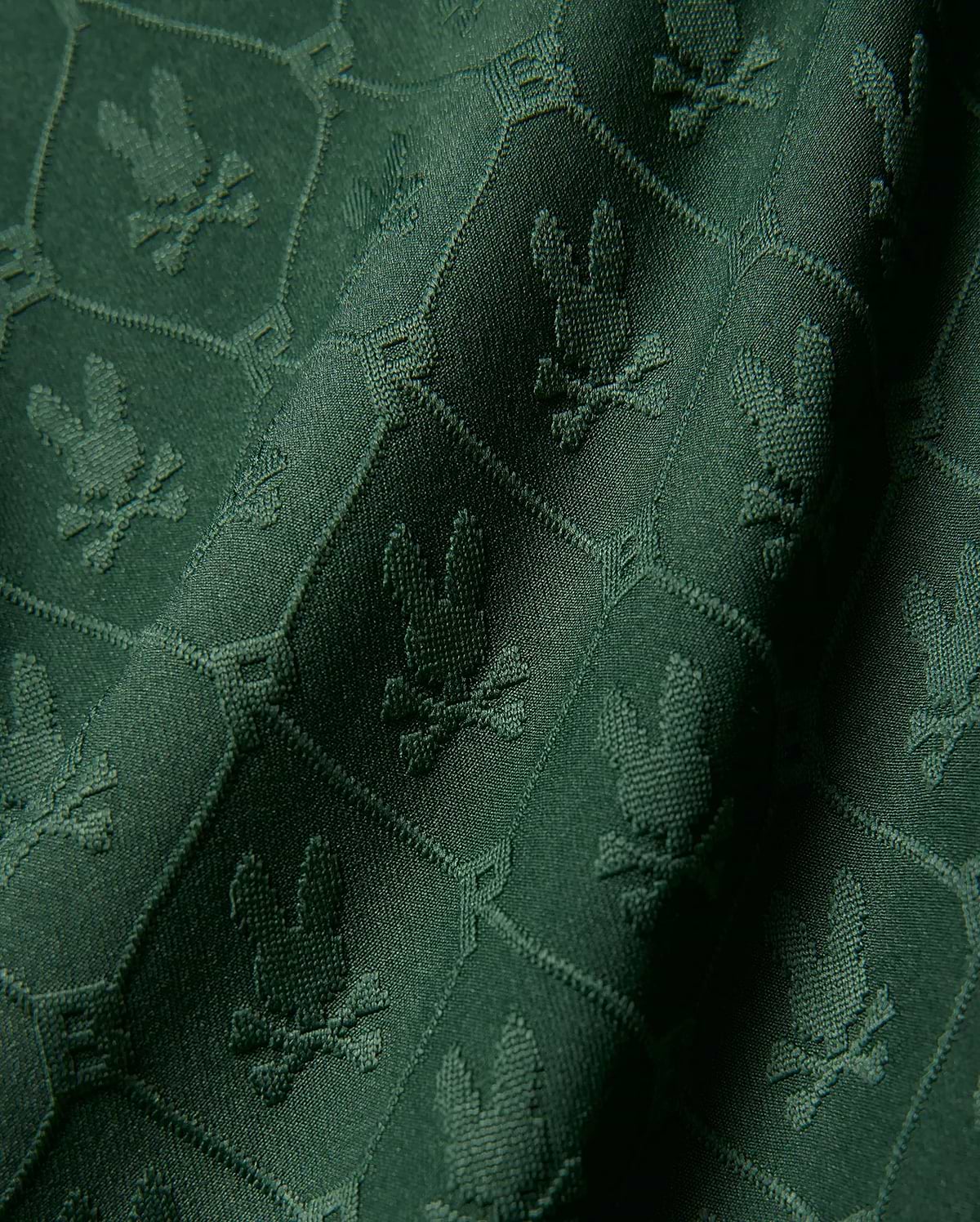 Kids Garry Jacquard Johnny Collar Polo in deep green, featuring an all-over tonal jacquard knit pattern of the iconic Psycho Bunny skull logo within a subtle geometric grid.