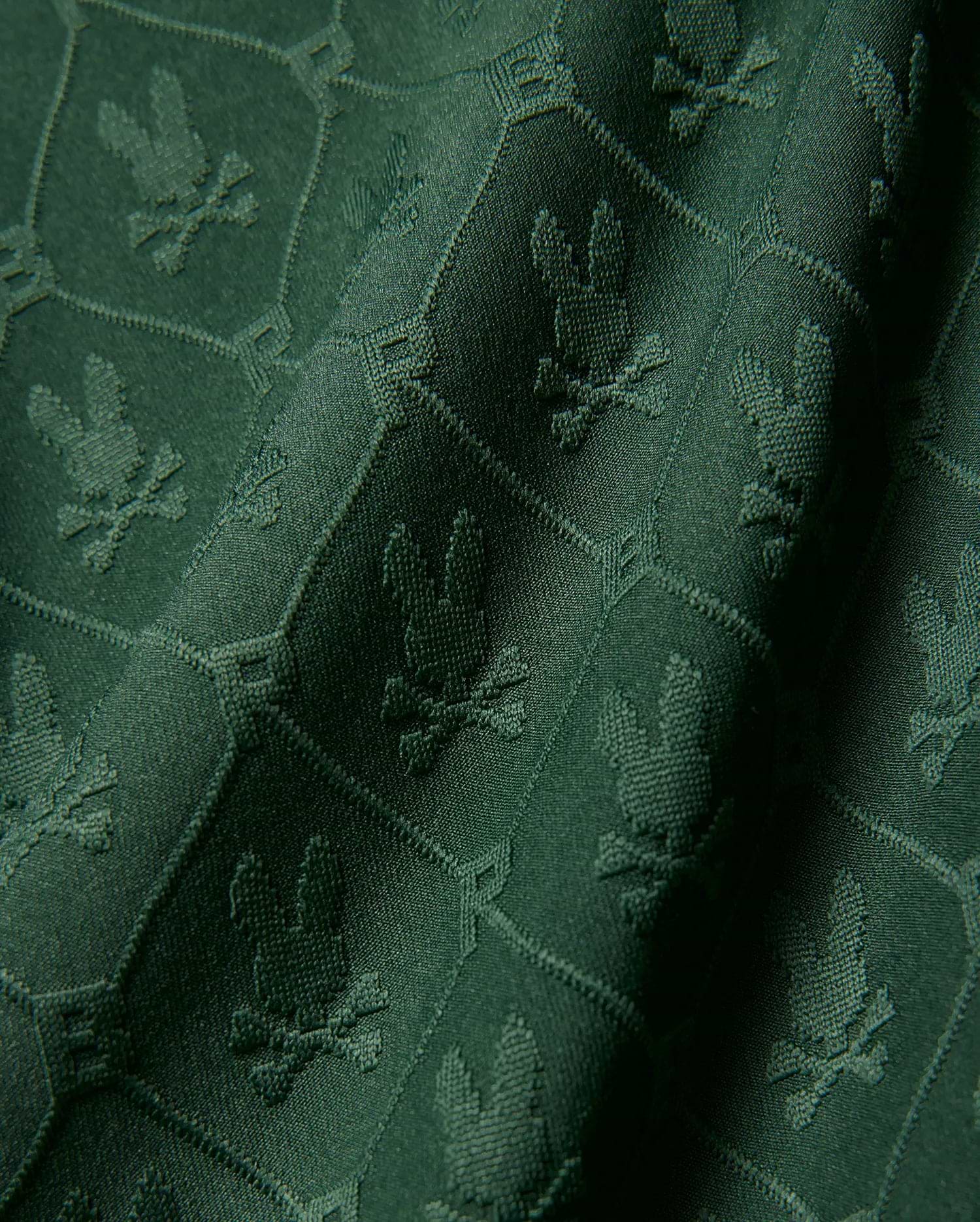 Kids Garry Jacquard Johnny Collar Polo in deep green, featuring an all-over tonal jacquard knit pattern of the iconic Psycho Bunny skull logo within a subtle geometric grid.