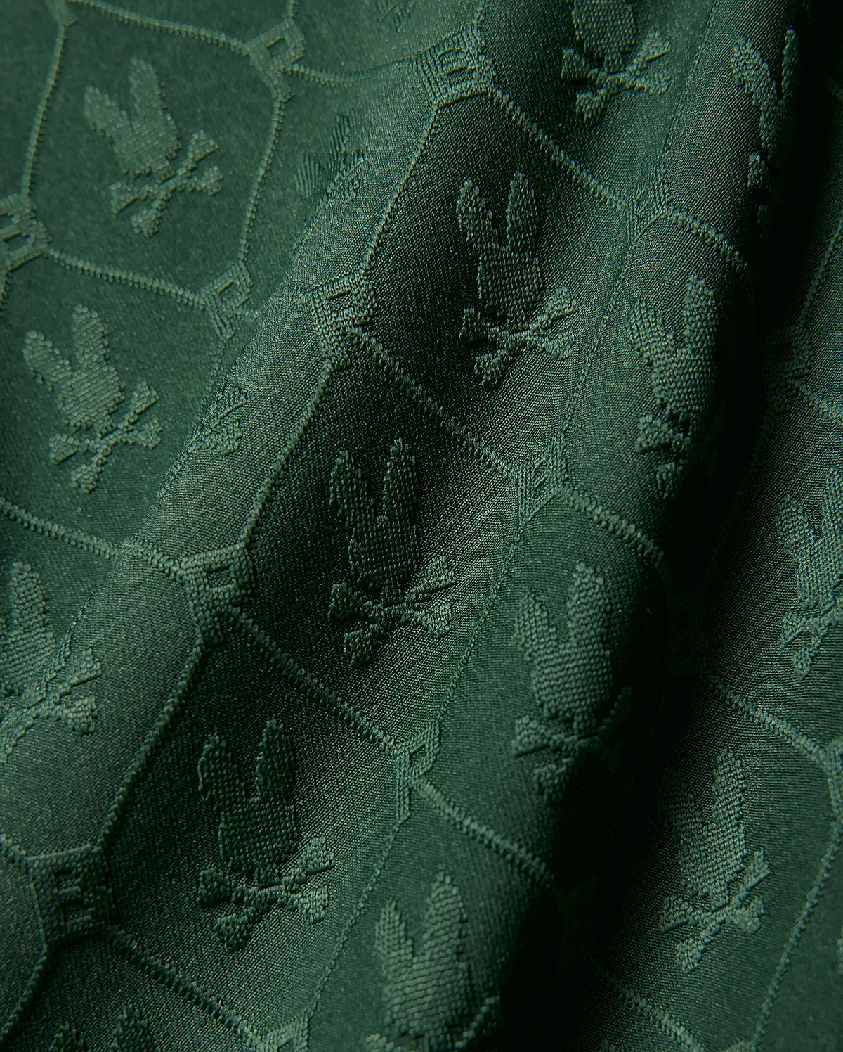 Kids Garry Jacquard Johnny Collar Polo in deep green, featuring an all-over tonal jacquard knit pattern of the iconic Psycho Bunny skull logo within a subtle geometric grid.
