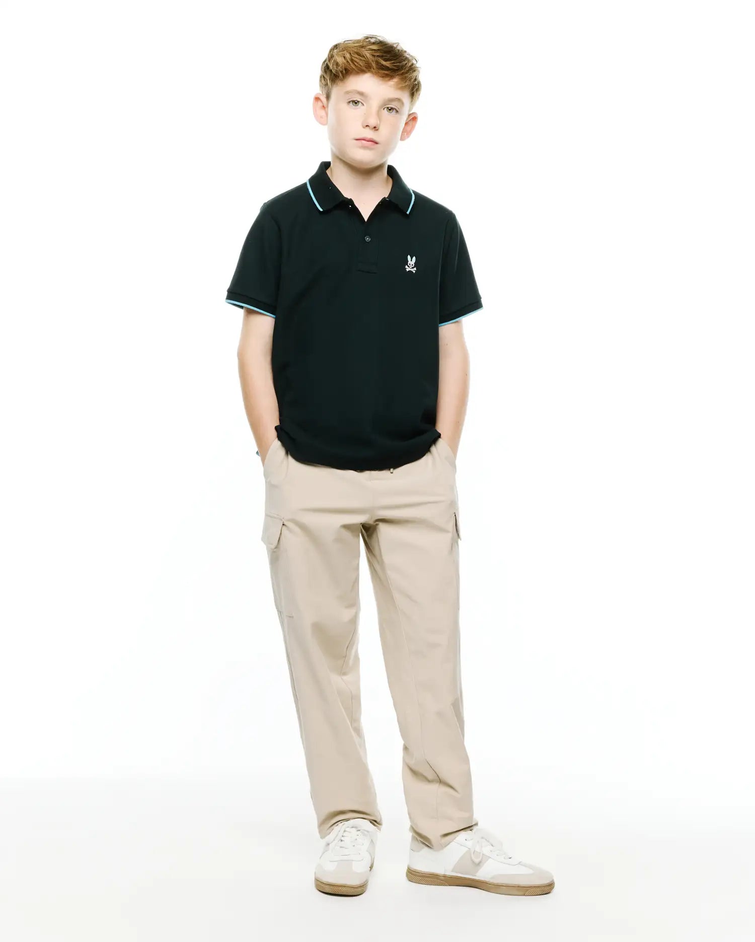Kids' Klaus Pique Polo in classic fit black pique fabric, featuring a small embroidered white Psycho Bunny skull logo on the left chest, with light blue tipping on the collar and sleeve cuffs. (4)