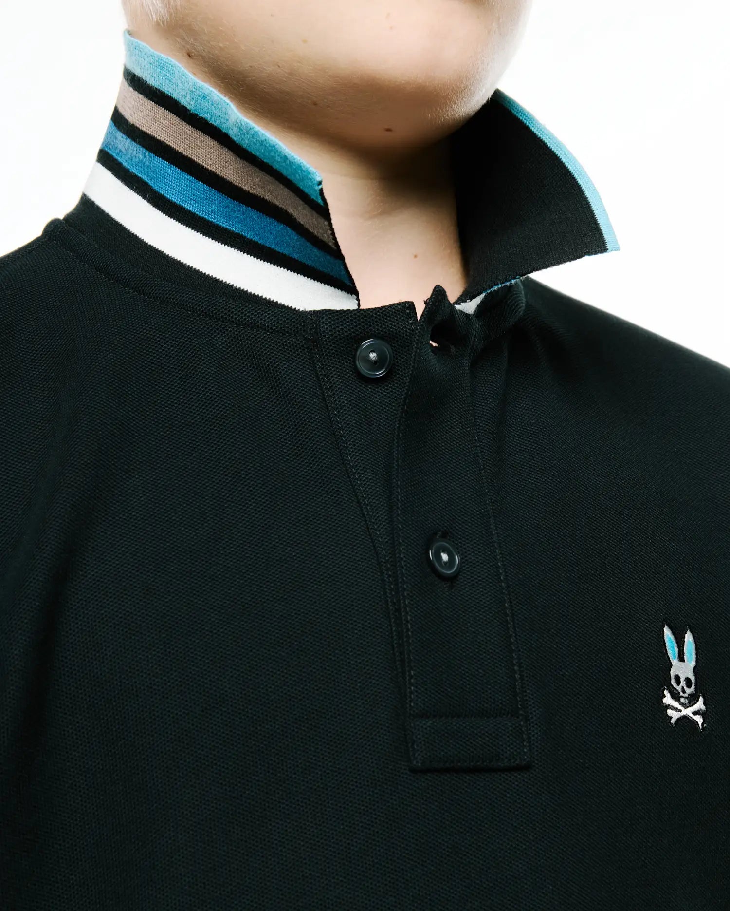 Kids' Klaus Pique Polo: dark green classic pique knit, two-button placket, striped ribbed collar (white, black, brown, blue), small embroidered blue-eared Psycho Bunny skull on right chest. (2)