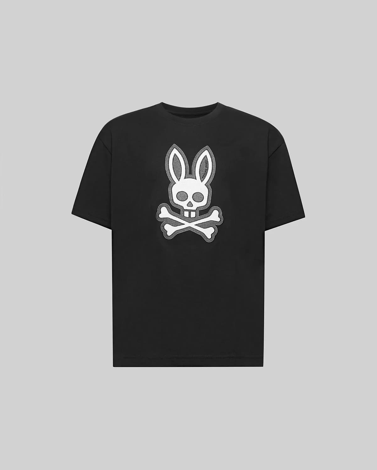 The Psycho Bunny KIDS RYDER OVERSIZED FIT TEE (KT0200056) is a black premium tee crafted from soft Pima cotton, featuring a white embroidered Bunny skull with bunny ears above crossed bones against a gray background.