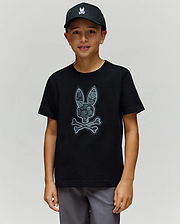 A boy in a black cap and the Psycho Bunny KIDS ROWEN BUNNY GRAPHIC TEE (KT0200058), crafted from soft Pima cotton in Peru, stands facing the camera against a plain light background. (1)