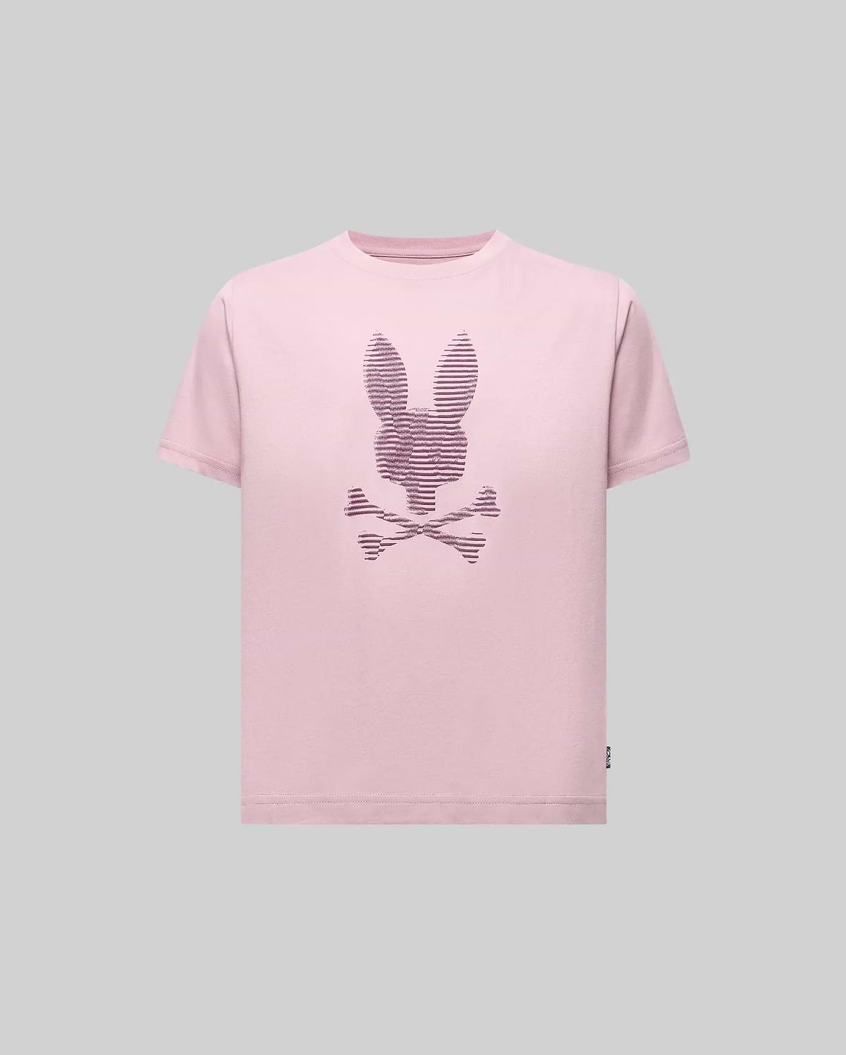 The Psycho Bunny KIDS GRANT BUNNY GRAPHIC TEE (KT0200061) features a light pink Pima cotton shirt with a bunny-head skull and crossbones design in thin dark lines, shown on a plain gray background.