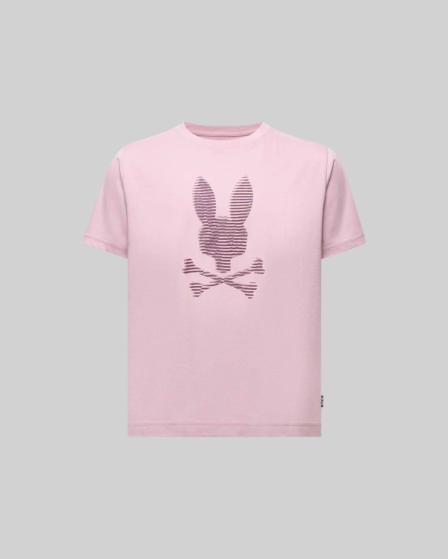The Psycho Bunny KIDS GRANT BUNNY GRAPHIC TEE (KT0200061) features a light pink Pima cotton shirt with a bunny-head skull and crossbones design in thin dark lines, shown on a plain gray background.
