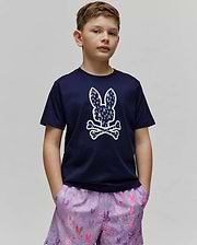 Kids Nev Bunny Graphic Tee. Navy blue classic fit jersey t-shirt featuring a large center chest Psycho Bunny skull logo, filled with a vibrant multi-color mini bunny skull pattern, with lavender all-over print shorts. (2)