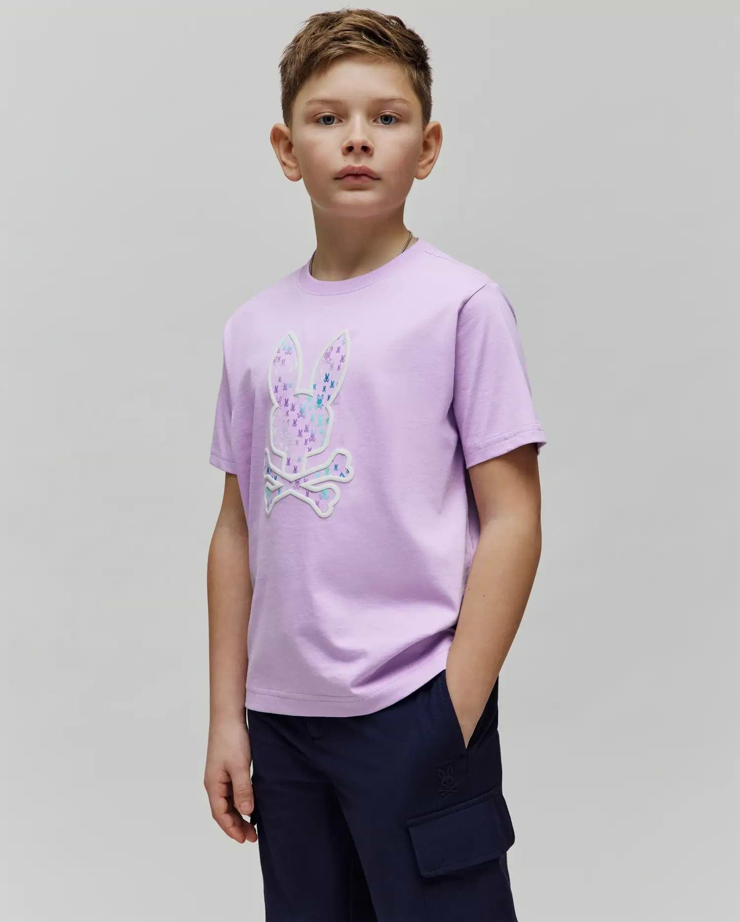 Kids Nev Bunny Graphic Tee, a classic fit lavender jersey t-shirt featuring a large central Psycho Bunny skull logo graphic filled with vibrant multi-color mini bunny patterns and a white outline. (2)