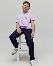 Kids Nev Bunny Graphic Tee in lilac jersey with a large iridescent patterned bunny skull logo on the chest, paired with navy relaxed fit pants. (4)