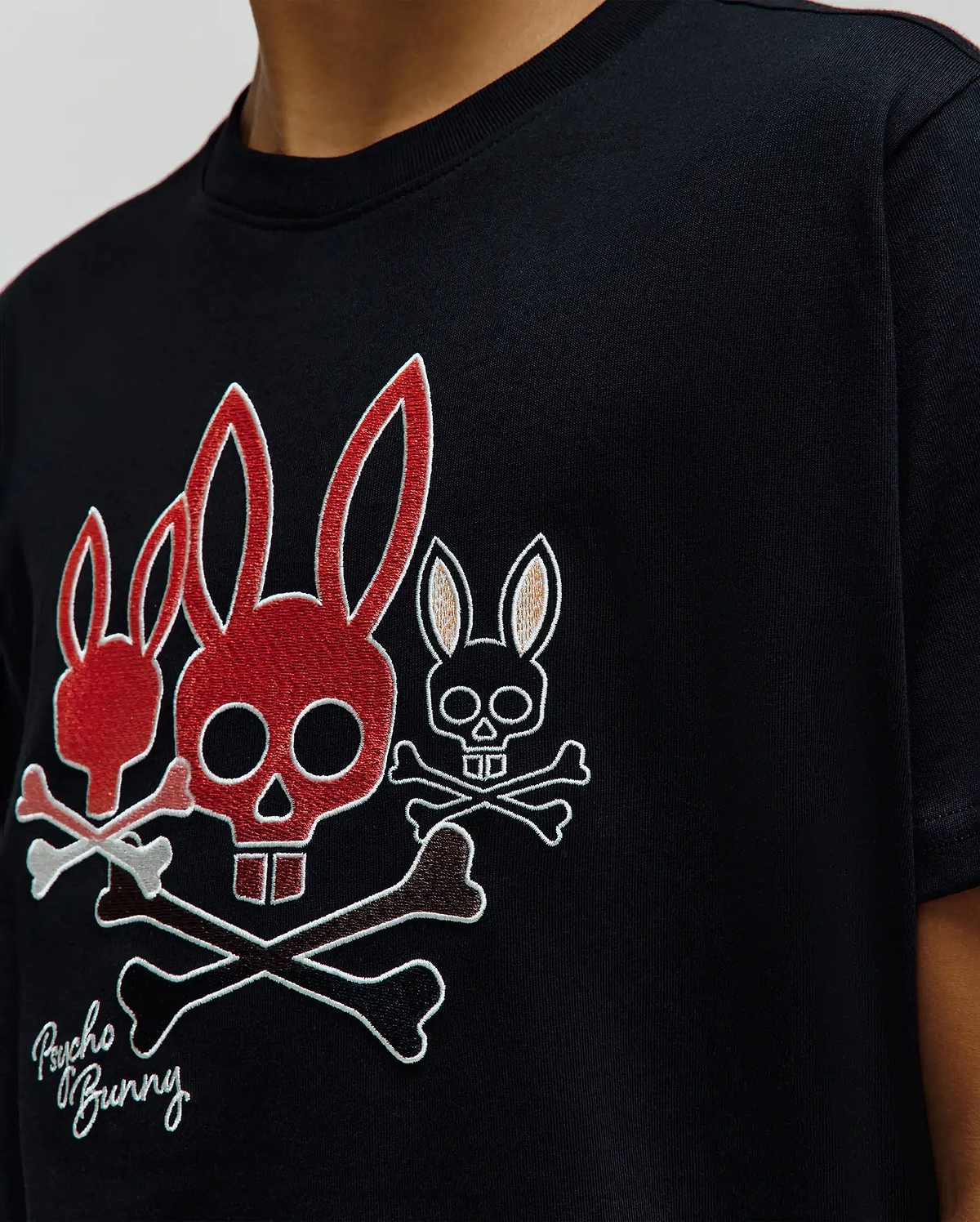 Black Kids Oscar Graphic Tee, classic fit jersey, with a large embroidered chest graphic of three red, white, and brown Psycho Bunny skull and crossbones, plus script branding. (3)