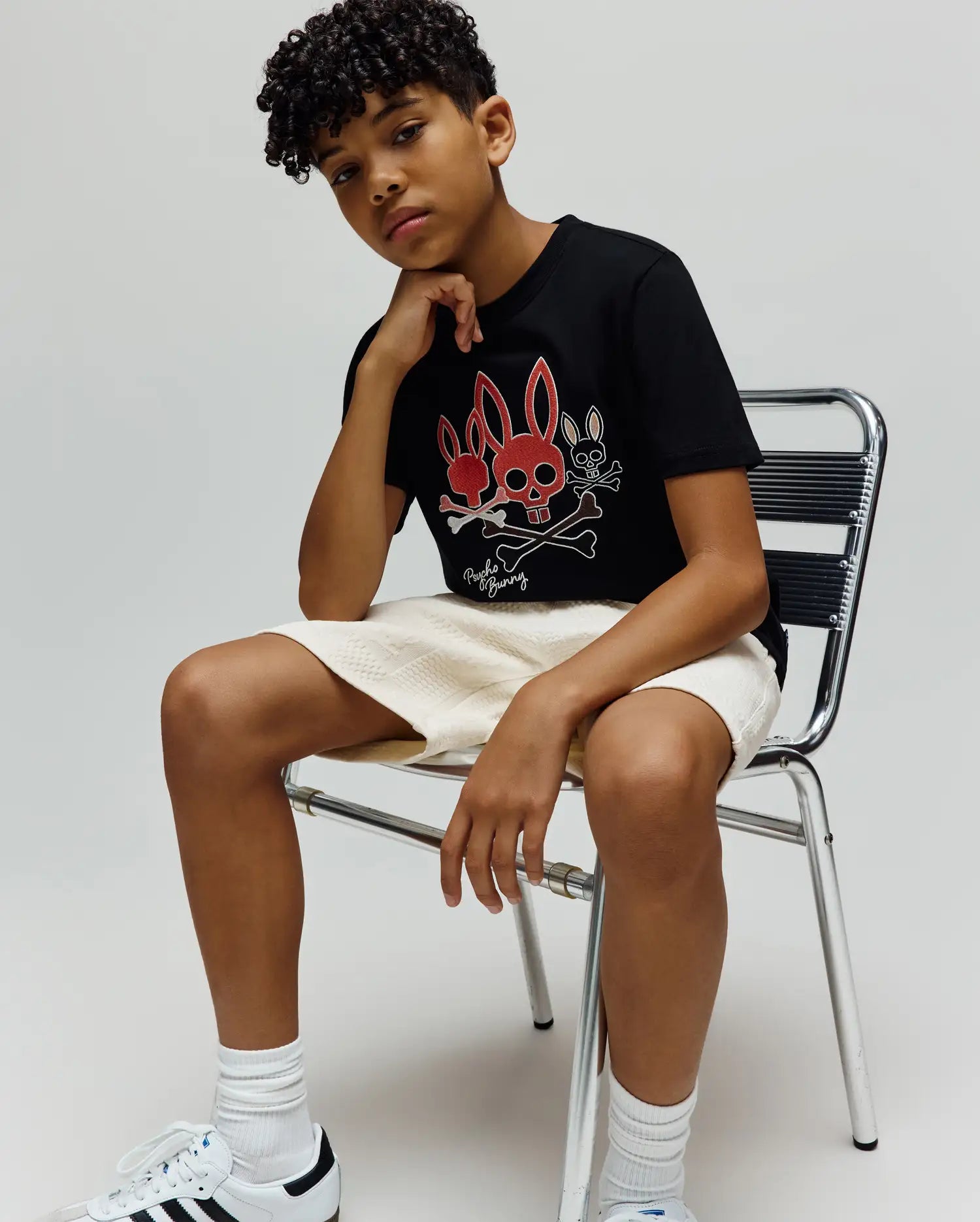 Kids Oscar Graphic Tee, black jersey knit, classic fit. Features a bold central graphic with two red bunny skulls, a white bunny skull, crossed bones, and Psycho Bunny text. (4)