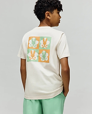 Kids Aiden Back Graphic Tee, a cream classic fit jersey t-shirt with a large back graphic featuring a checkerboard of orange and mint green Psycho Bunny skull logos.