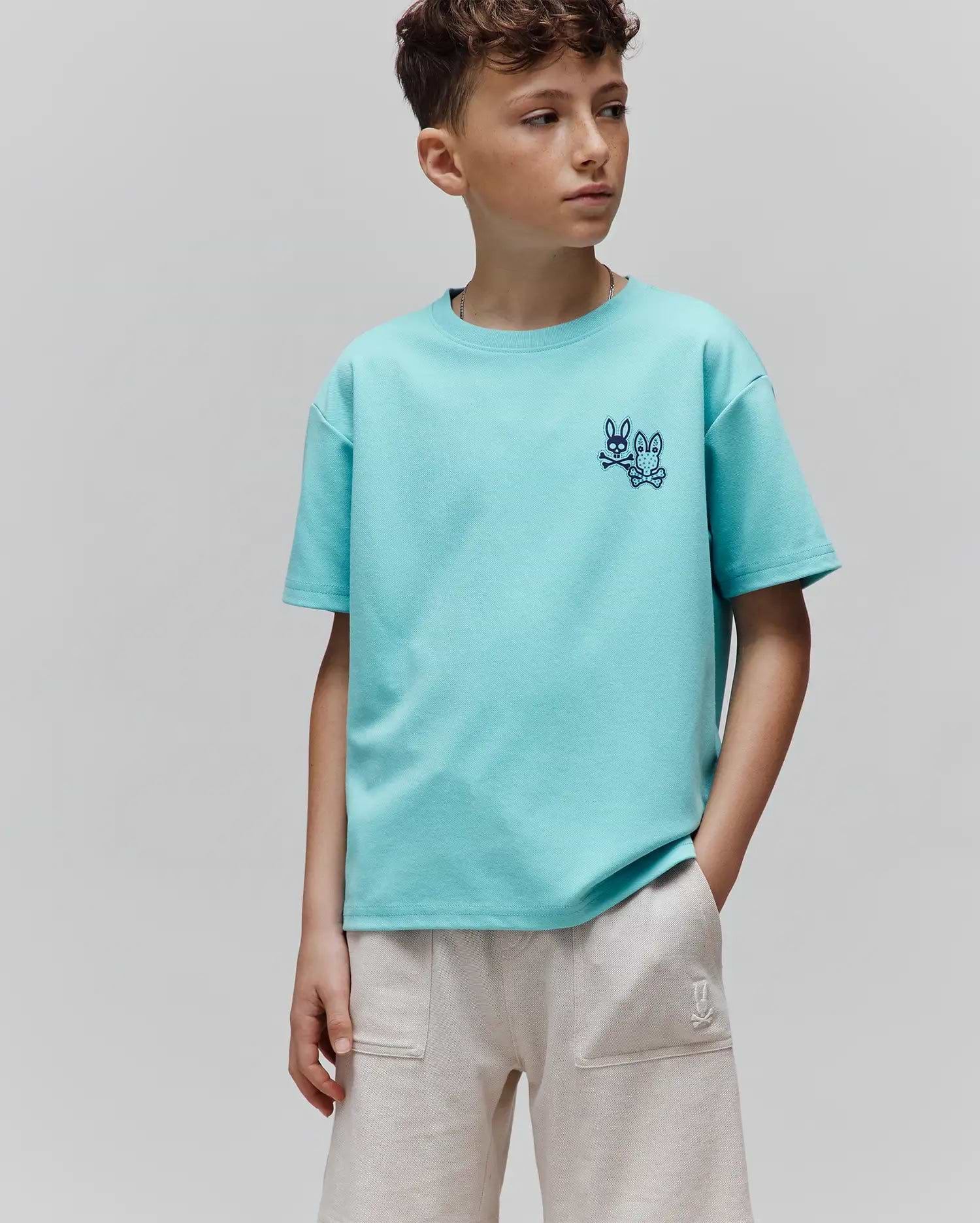 Kids Luke Back Graphic Tee in aqua pique knit, featuring a relaxed fit and two small, embroidered dark blue Psycho Bunny skull and crossbones logos on the left chest.