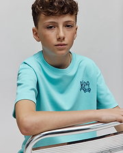 Kids Luke Back Graphic Tee in aqua smooth jersey, featuring a classic fit and a small, dark blue embroidered Psycho Bunny skull logo on the left chest.