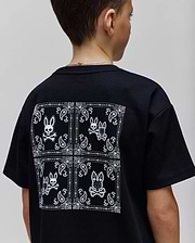 Kids Luke Back Graphic Tee, a black classic fit jersey t-shirt with a large white bandana-style graphic on the back featuring multiple Psycho Bunny skull logos and paisley patterns.