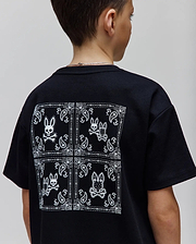 Kids Luke Back Graphic Tee, a black classic fit jersey t-shirt with a large white bandana-style graphic on the back featuring multiple Psycho Bunny skull logos and paisley patterns.