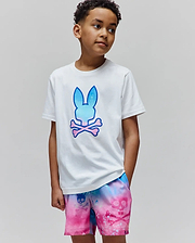 White Kids Caspian Graphic Tee, classic fit, soft jersey, with a large gradient blue-to-pink Psycho Bunny skull logo. Paired with vibrant tie-dye shorts featuring an all-over pink skull pattern.