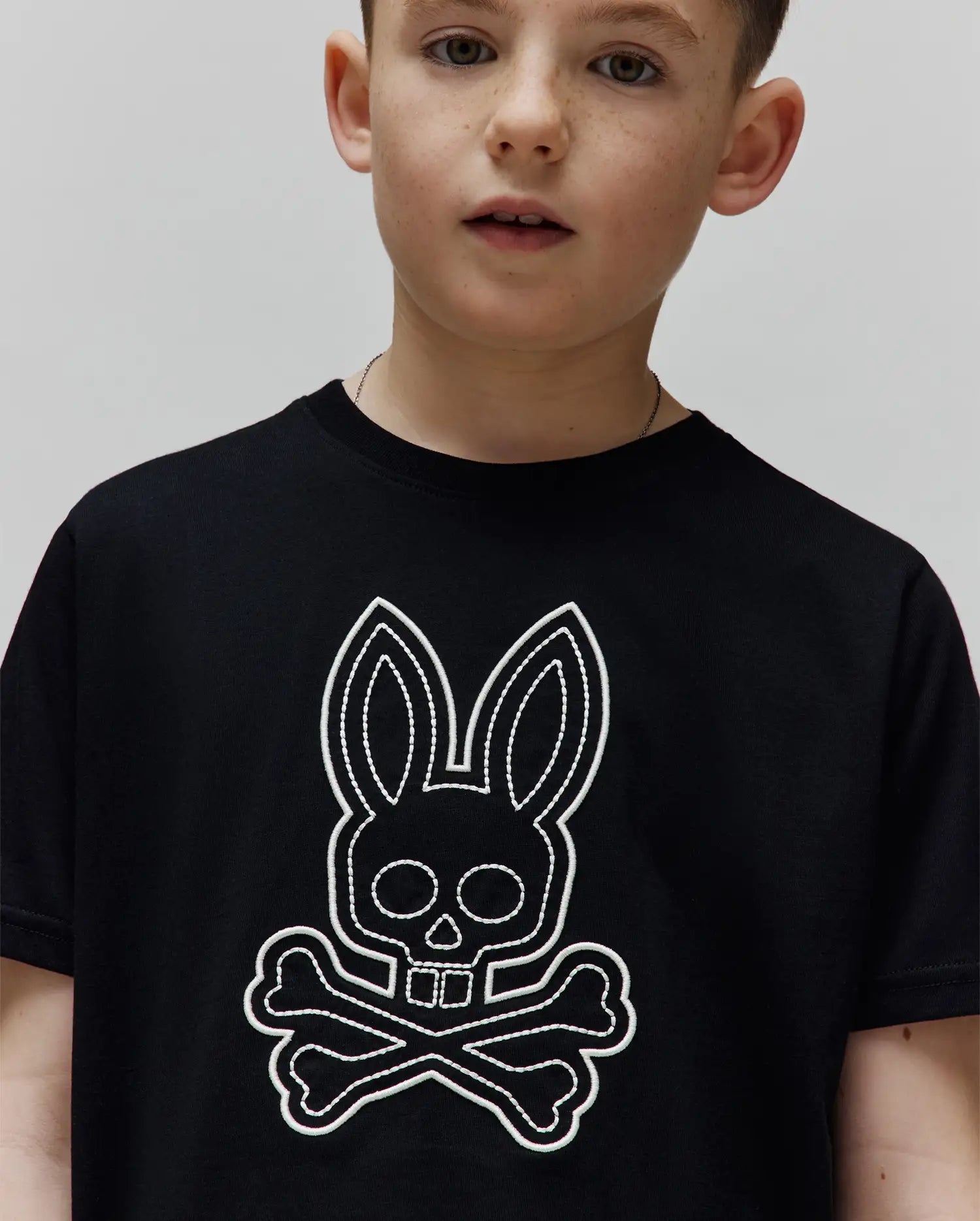 Kids Marcel Graphic Tee, black jersey t-shirt with a large white embroidered Psycho Bunny skull and crossbones graphic on the chest, classic fit.