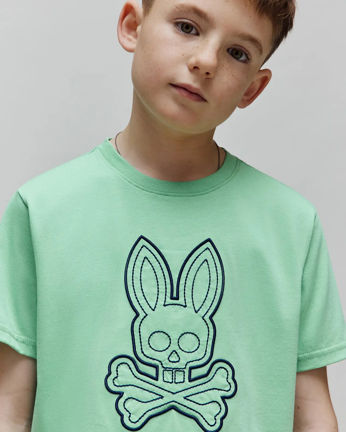 Kids Marcel Graphic Tee in mint green, featuring a large, central dark blue embroidered Psycho Bunny skull and crossbones logo on soft jersey knit fabric with a classic fit. (3)