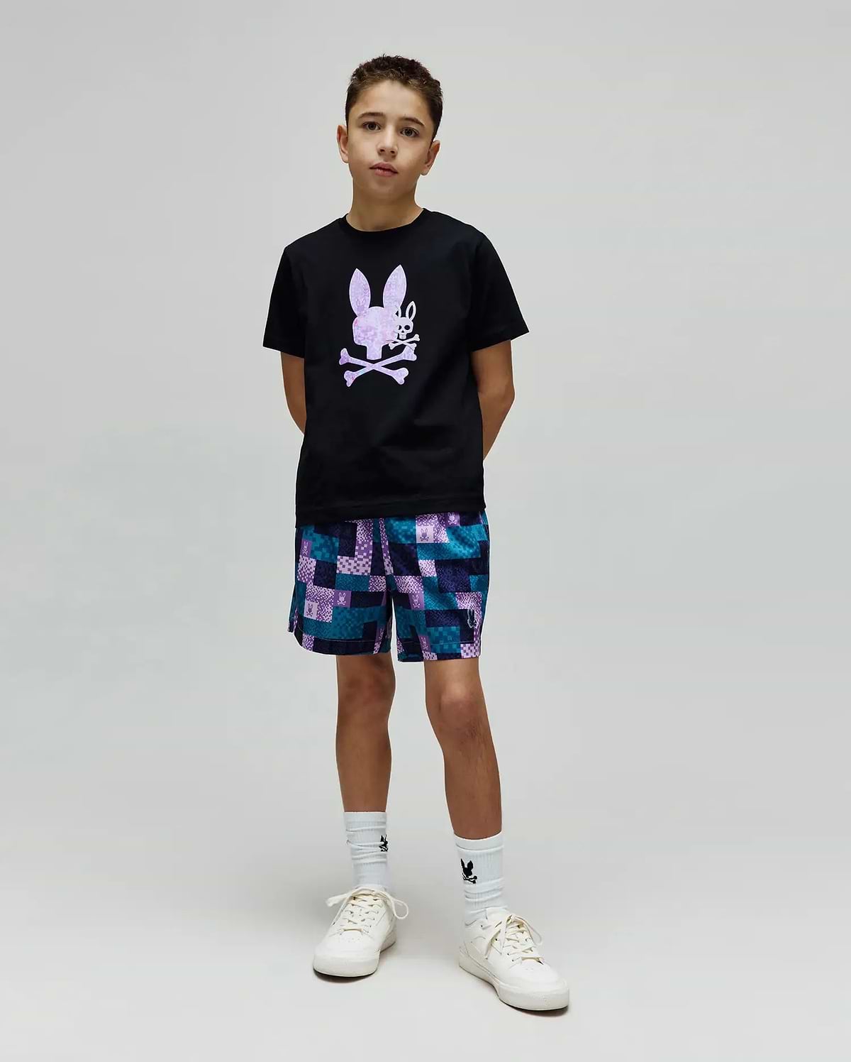 Kids Van Graphic Tee, a black jersey t-shirt with a large purple textured bunny skull chest graphic, paired with relaxed teal, purple, blue patchwork shorts featuring small bunny skull logos. (4)