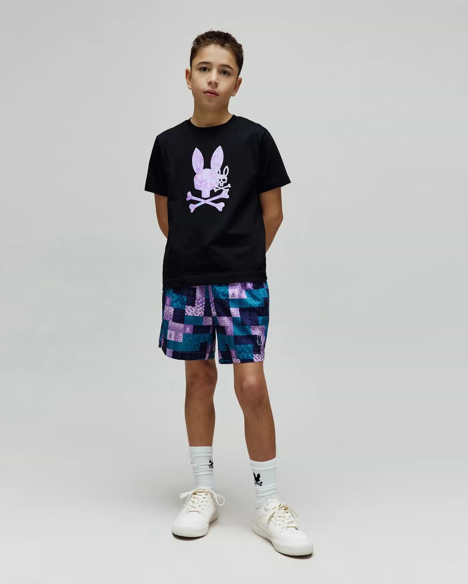Kids Van Graphic Tee, a black jersey t-shirt with a large purple textured bunny skull chest graphic, paired with relaxed teal, purple, blue patchwork shorts featuring small bunny skull logos. (4)