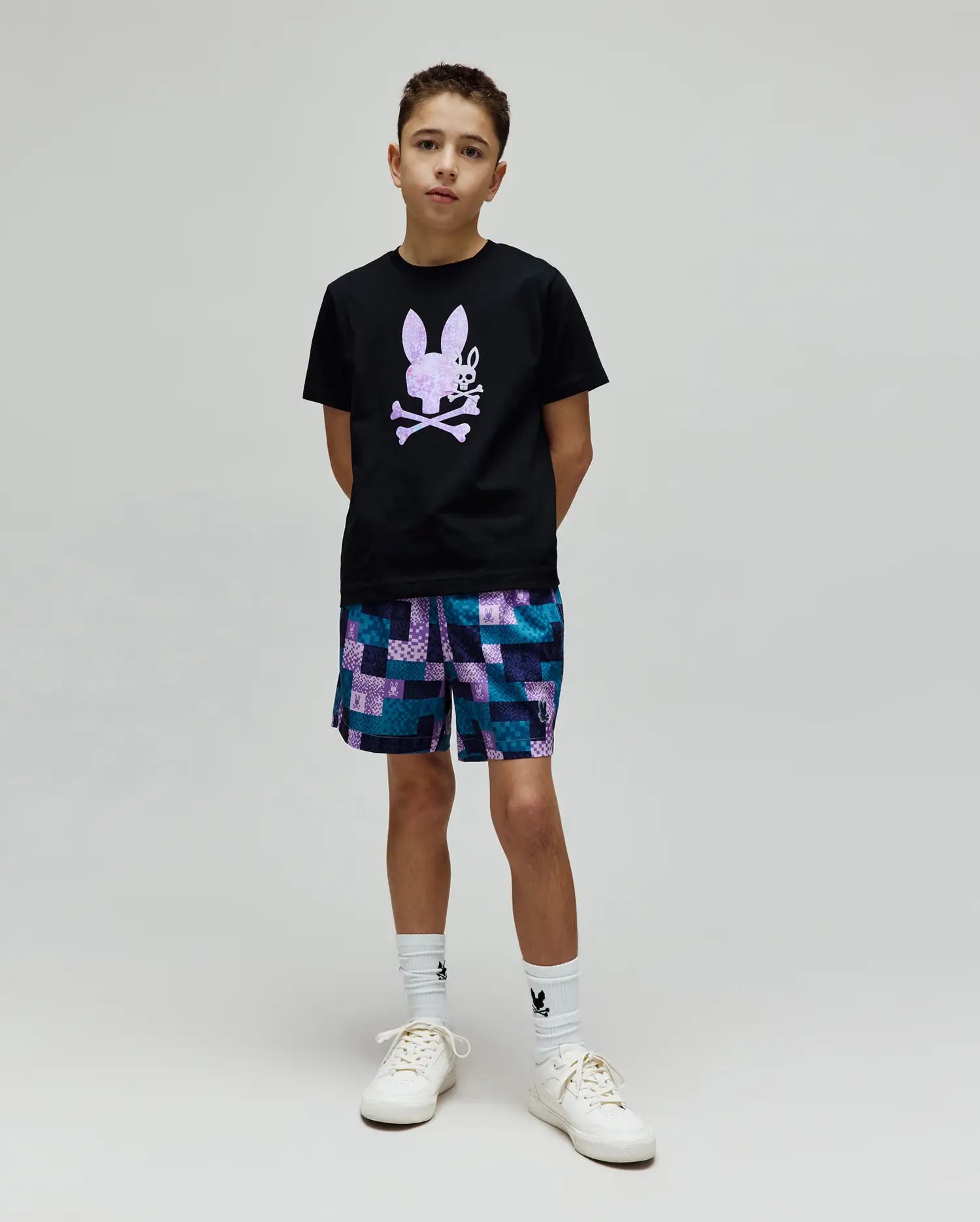 Kids Van Graphic Tee, a black jersey t-shirt with a large purple textured bunny skull chest graphic, paired with relaxed teal, purple, blue patchwork shorts featuring small bunny skull logos. (4)