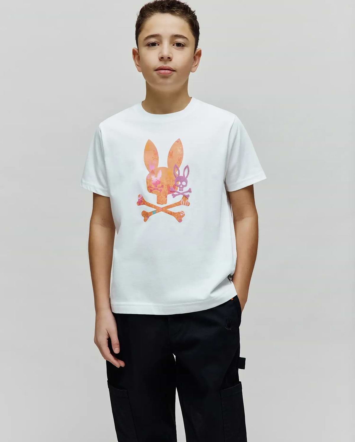 Kids Van Graphic Tee: White classic fit jersey t-shirt featuring a large center chest graphic of an orange and pink patterned bunny skull with a smaller purple bunny skull and crossed bones. (2)