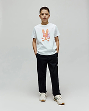 White Kids Van Graphic Tee in classic fit, featuring a large orange, pink, and purple watercolor-style Psycho Bunny skull logo with a subtle van pattern and crossed bones on the chest, made from soft jersey fabric. (4)