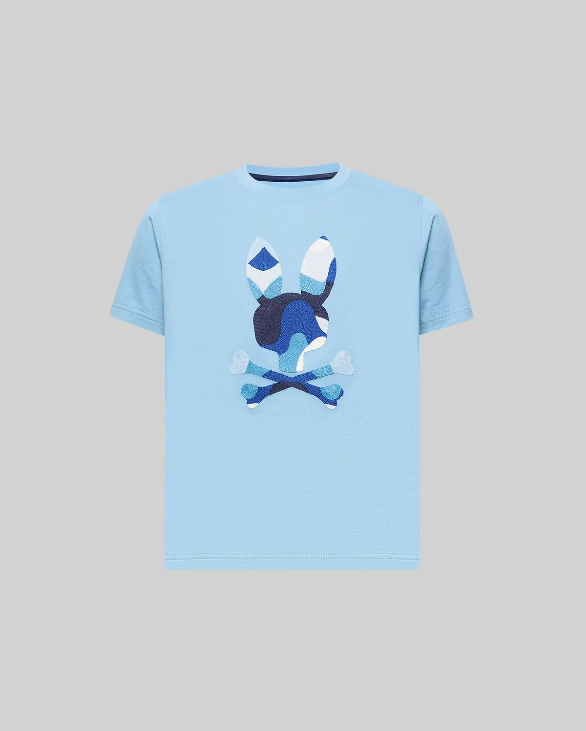 Kids Ara Graphic Tee, a classic fit sky blue jersey knit t-shirt featuring a large, center chest Psycho Bunny skull logo with a distinctive blue and white camouflage pattern.