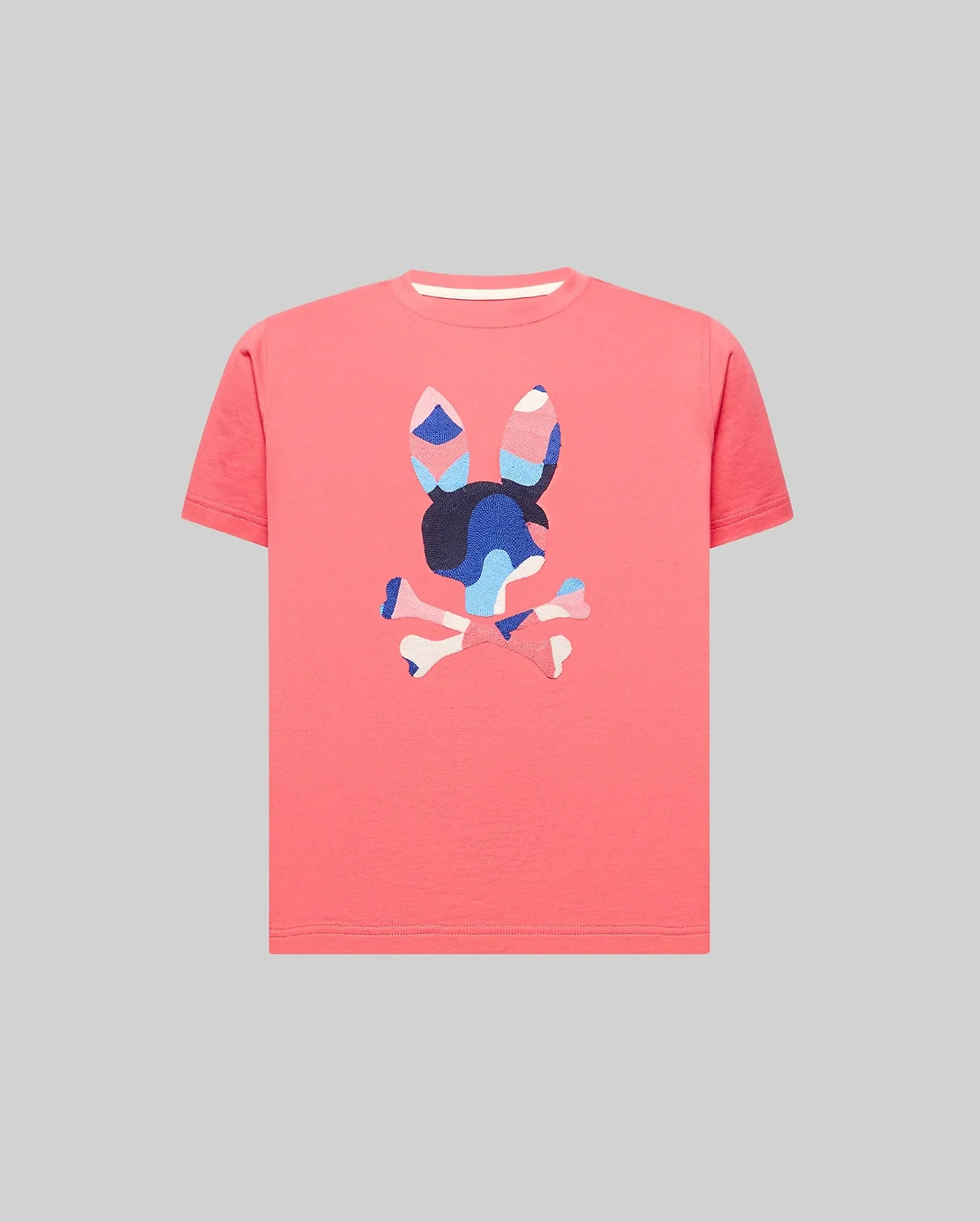 Kids Ara Graphic Tee in vibrant coral, crafted from soft jersey knit with a classic fit. Features a large, textured, multi-color camouflage Psycho Bunny skull logo prominently on the chest.