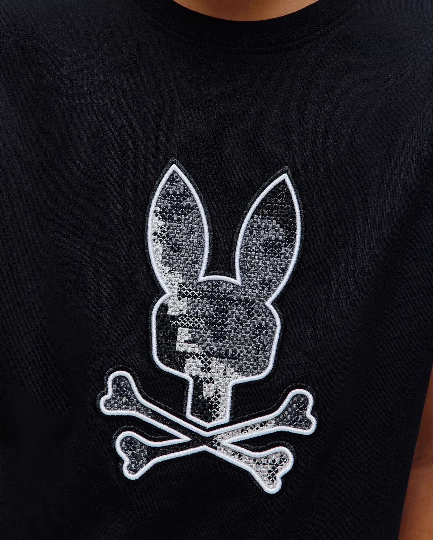 Kids Olivier Graphic Tee, black jersey knit with a large central embroidered Psycho Bunny skull logo featuring a grey pixelated pattern and white outline. (3)