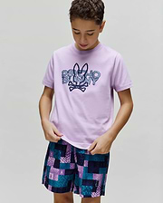 Kids Herman Graphic Tee in smooth lavender jersey, featuring a large pixelated blue Psycho Bunny logo on the chest, paired with vibrant multi-color pixelated shorts with subtle bunny skull branding. (2)