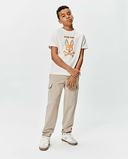 Kids Adler Graphic Tee in cream jersey with a classic fit, featuring a large orange and brown Psycho Bunny skull graphic and brand name on the chest.