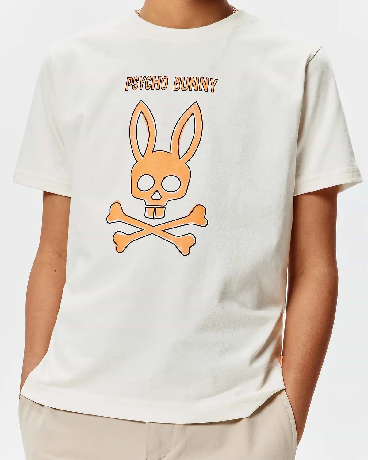 Kids Adler Graphic Tee, a cream classic fit jersey t-shirt with a large central orange and black Psycho Bunny skull and crossbones graphic and PSYCHO BUNNY text.