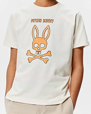 Kids Adler Graphic Tee, a cream classic fit jersey t-shirt with a large central orange and black Psycho Bunny skull and crossbones graphic and PSYCHO BUNNY text.