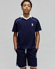 Kids Toby Jersey navy blue jersey top with white V-neck collar, white shoulder piping, and small embroidered Psycho Bunny logo. Matching navy shorts have white hem piping, drawstrings, and a larger Psycho Bunny logo.