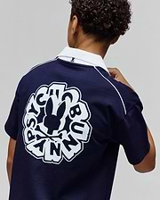 Kids Toby Jersey navy blue classic fit polo shirt with white collar, white shoulder piping, small embroidered bunny skull on collar, and large white Psycho Bunny text and skull graphic on back.