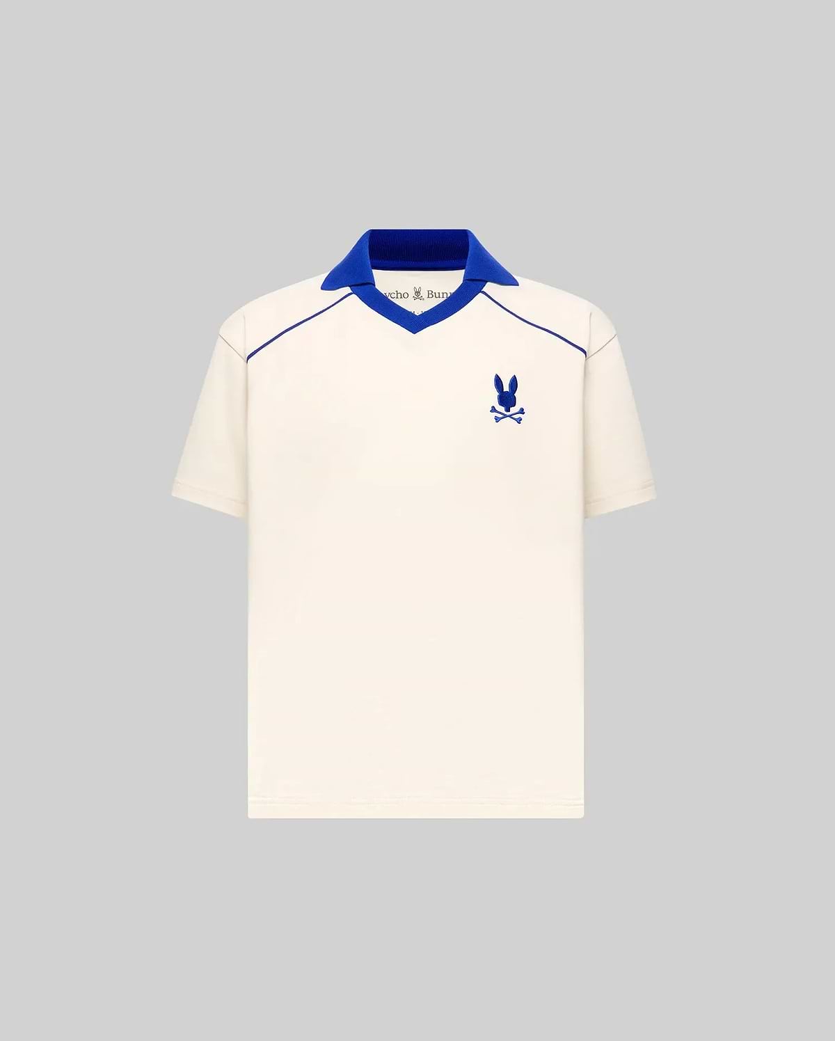 Kids Toby Jersey cream jersey polo with royal blue ribbed V-neck spread collar, V-neck and shoulder piping, and embroidered Psycho Bunny skull logo on the left chest, classic fit.