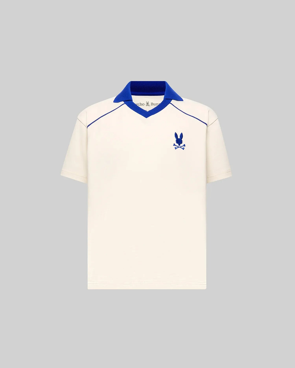 Kids Toby Jersey cream jersey polo with royal blue ribbed V-neck spread collar, V-neck and shoulder piping, and embroidered Psycho Bunny skull logo on the left chest, classic fit.