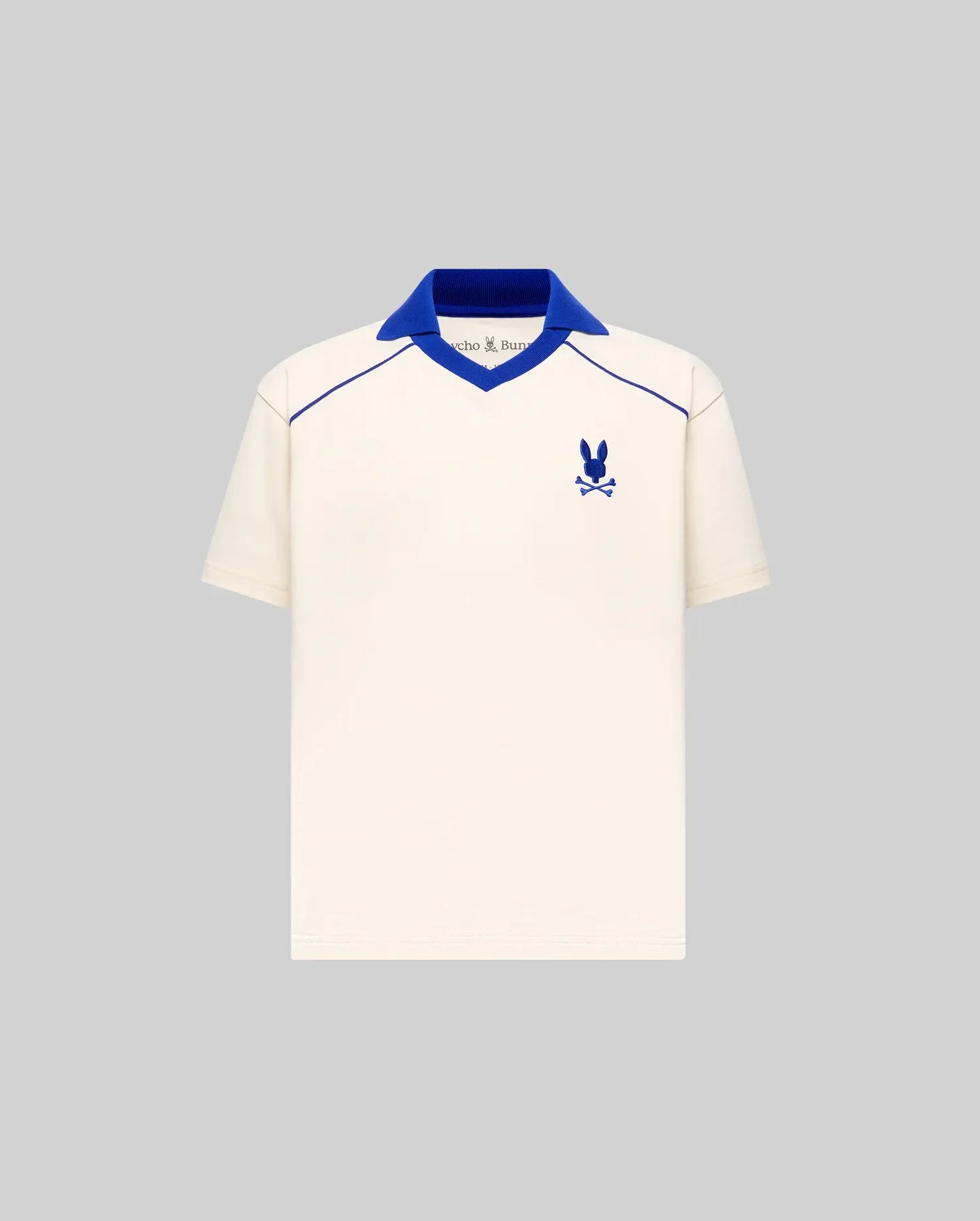 Kids Toby Jersey cream jersey polo with royal blue ribbed V-neck spread collar, V-neck and shoulder piping, and embroidered Psycho Bunny skull logo on the left chest, classic fit.