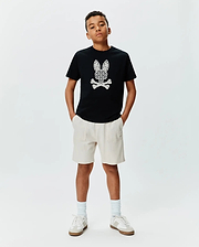 Black cotton jersey KIDS BRAD GRAPHIC TEE with a large, intricate white Psycho Bunny skull graphic on the chest, paired with cream relaxed-fit French terry shorts featuring a small embroidered logo.