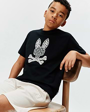 Kids Brad Graphic Tee, black cotton jersey, classic fit, featuring a large white Psycho Bunny skull and crossbones graphic with intricate palm tree and scale patterns, and a small blue hem tag.
