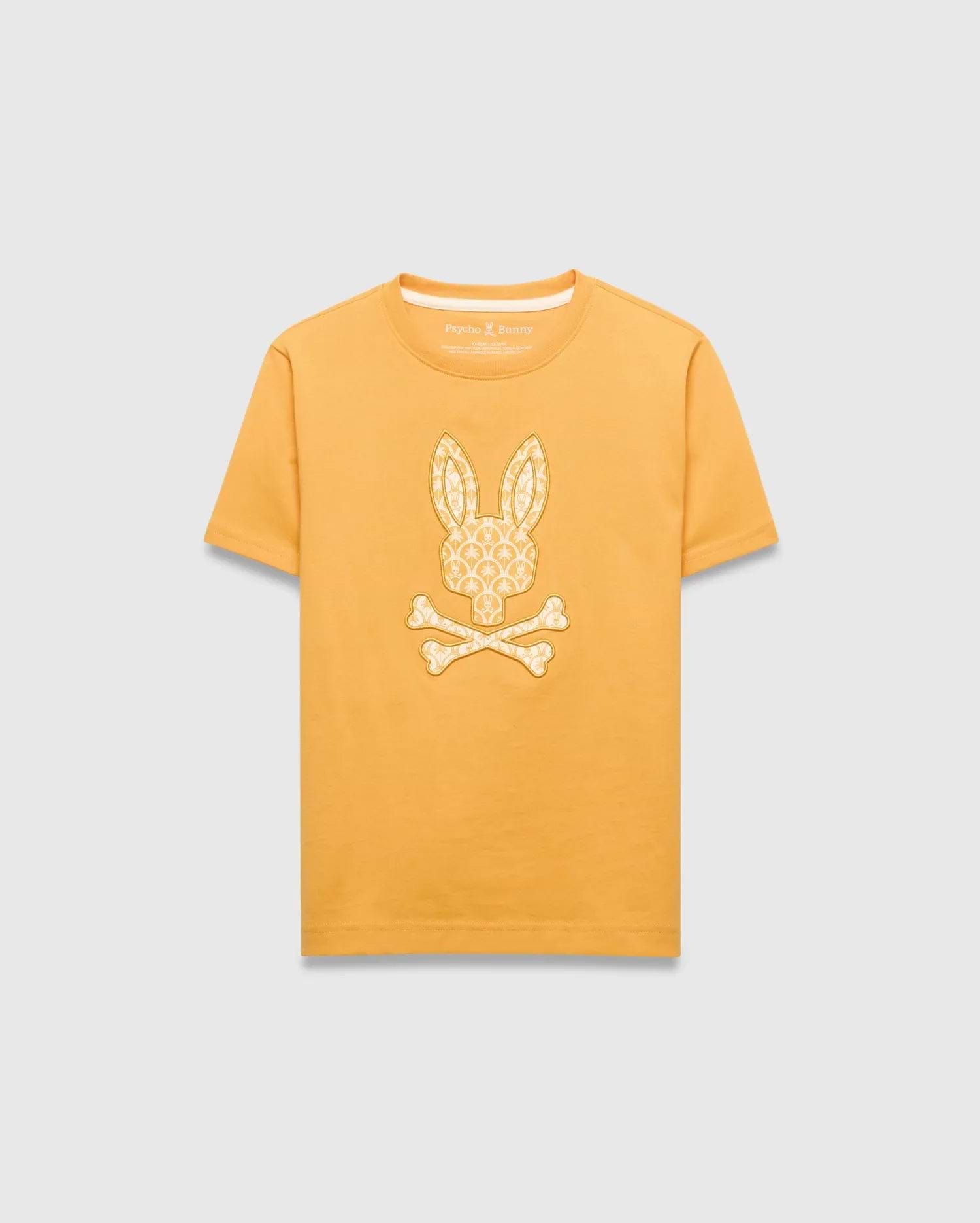 Kids Brad Graphic Tee in golden yellow jersey knit, featuring a large central off-white Psycho Bunny skull logo graphic filled with a subtle repeating bunny pattern, classic fit.