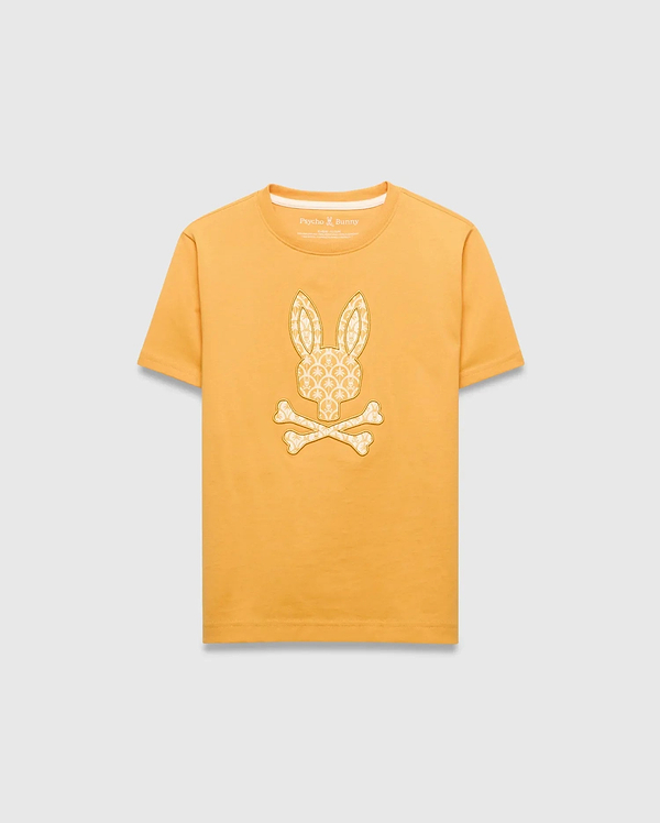 Kids Brad Graphic Tee in golden yellow jersey knit, featuring a large central off-white Psycho Bunny skull logo graphic filled with a subtle repeating bunny pattern, classic fit.