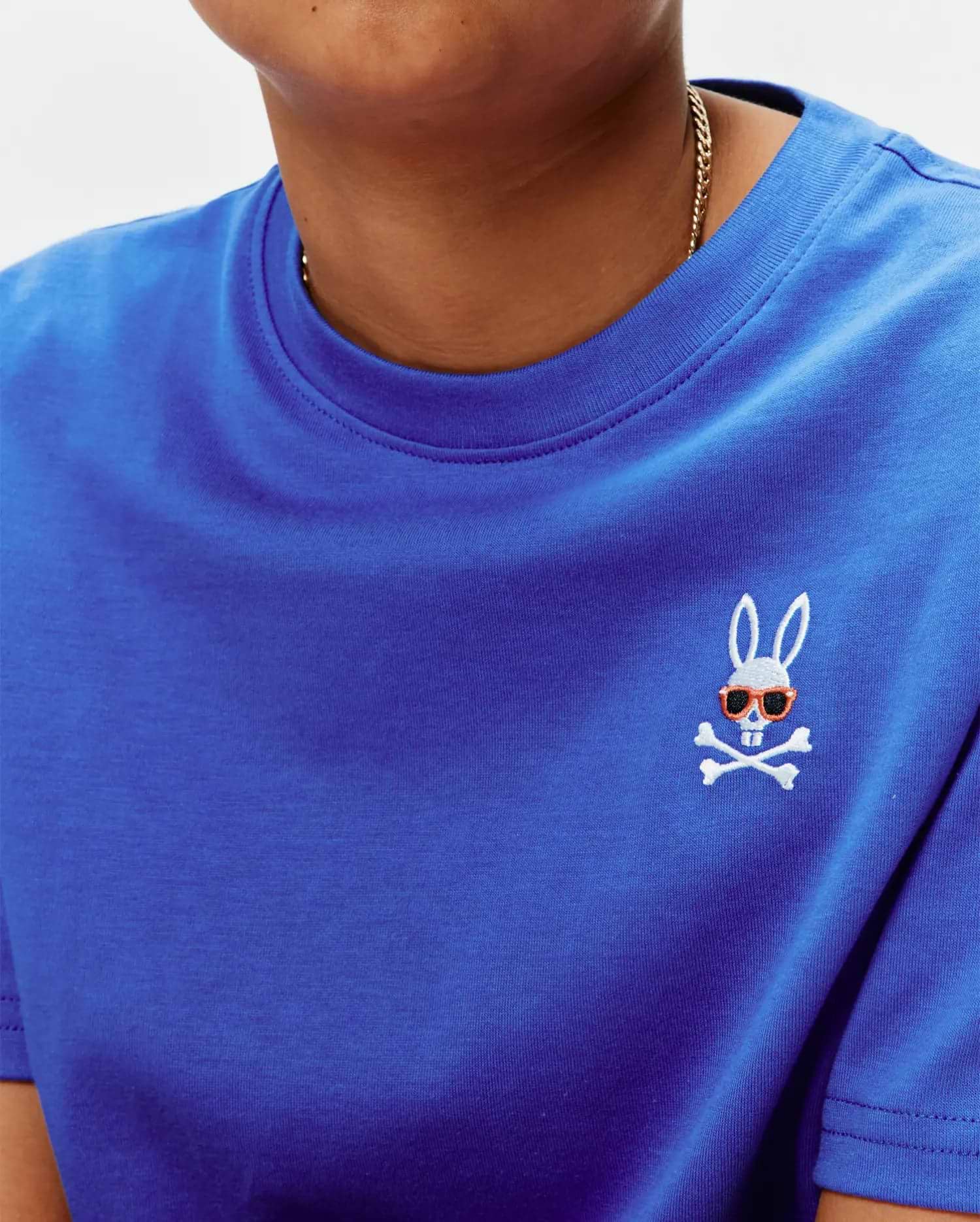 Royal Blue Kids Sunny Chest Graphic Tee, classic fit jersey knit, featuring a small embroidered white Psycho Bunny skull logo with orange sunglasses on the left chest.