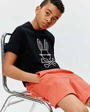 Black Kids Craig Graphic Tee, a classic-fit jersey tee featuring a prominent white Psycho Bunny skull logo graphic on the chest, paired with coral relaxed-fit woven shorts. (2)